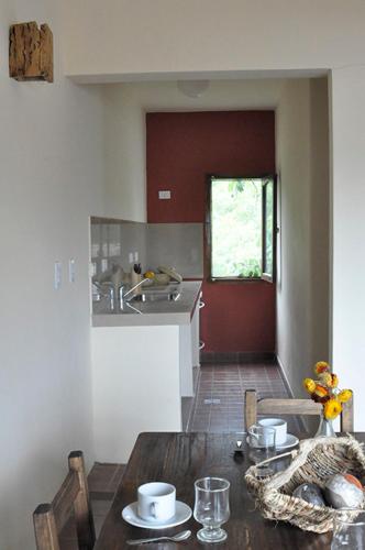 a kitchen with a wooden table with chairs and a sink at Kamay Apart Cafayate in Cafayate