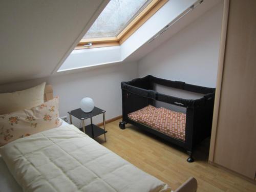 Schlafzimmer im Dachgeschoss mit einem Bett und einem Dachfenster in der Unterkunft Ferienwohnungen Krauss in Ringsheim