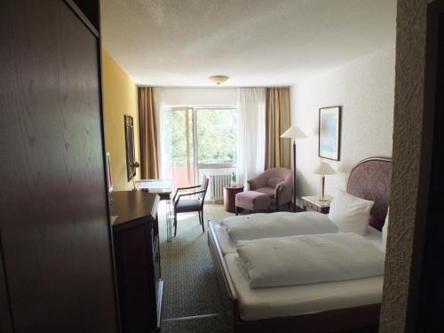 ein Hotelzimmer mit einem Bett, einem Schreibtisch und einem Stuhl in der Unterkunft Hotel Moselkern in Moselkern