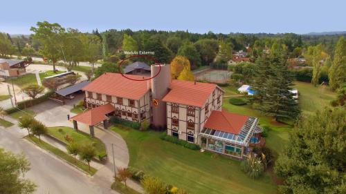 una vista aérea de una casa con techo rojo en Berna Hotel & Spa en Villa General Belgrano