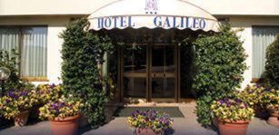 a hotel entrance with pots of flowers in front of it at Park Hotel Galileo in Reggello