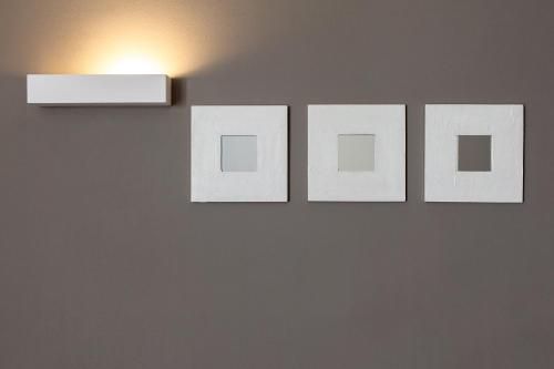 four white pictures hanging on a wall with a light at Hotel Spa Calagrande Cabo de Gata in Las Negras
