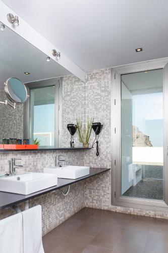 a bathroom with two sinks and a large mirror at Hotel Spa Calagrande Cabo de Gata in Las Negras