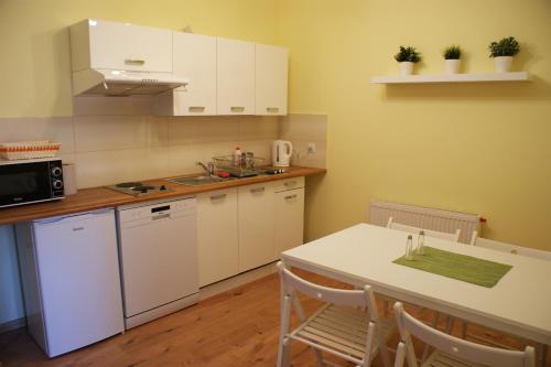 a kitchen with white appliances and a table with chairs at Majówka w Karkonoszach II in Kowary