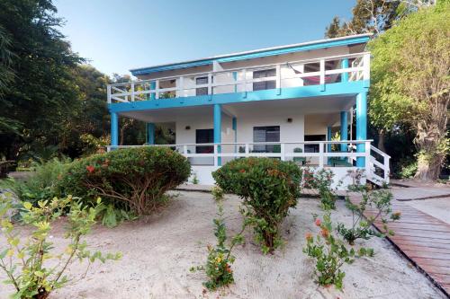 a blue and white house on the beach at Condo #31 @ Beachside Villas in Placencia Village
