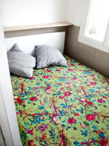 un letto con una coperta di fiori e due cuscini di Le Calypso a Marseillan