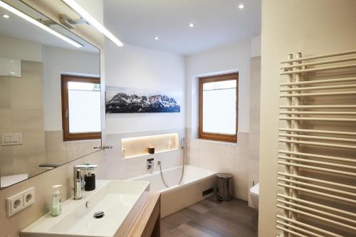 a white bathroom with a sink and a mirror at Top modernes Ferienhaus mit Sauna! Nicht weit vom Skilift in Kirchberg in Tirol