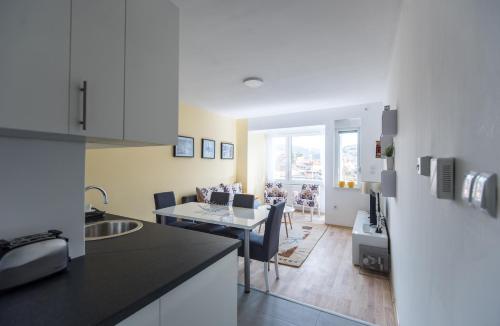 Una cocina y una sala de estar con mesa y sillas. en Sunrise Inn Sarajevo, en Sarajevo