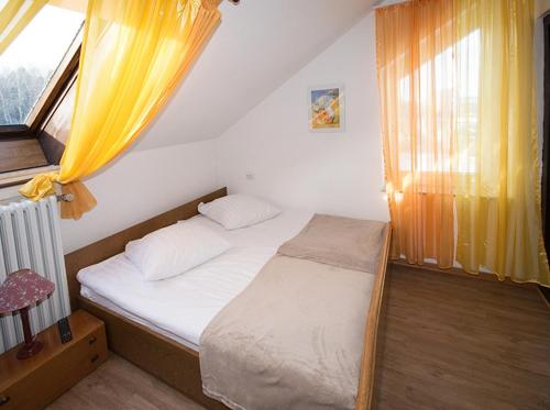 a small bedroom with a bed and a window at Hotel & Hostel Drei Bären in Altenau
