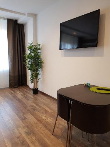 a dining room with a table and a tv on the wall at Bsuites Scrovegni in Padova