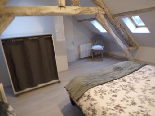 um quarto no sótão com uma cama e uma janela em les glycines em Cressonsacq