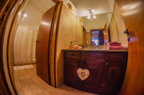 een badkamer met een wastafel en een spiegel bij Santa Rosa in La Cumbre