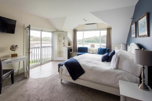 a bedroom with a large bed and a balcony at The Nonantum Resort in Kennebunkport
