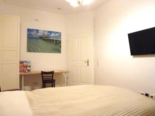 a bedroom with a bed and a desk and a television at All you need - Room in Hamburg