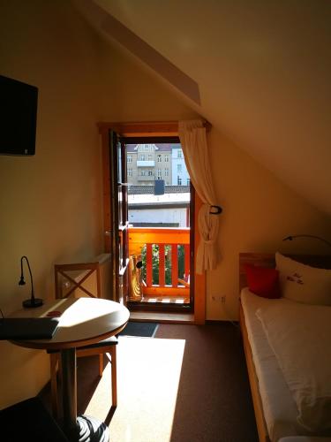 a bedroom with a bed and a window with a balcony at Hotel & Restaurant Wilder Eber in Eberswalde-Finow