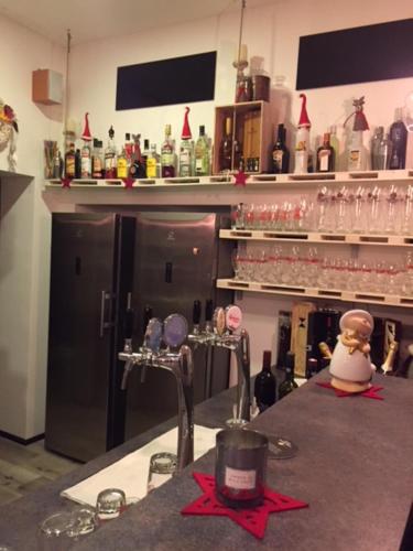 a kitchen with a counter with glasses and a refrigerator at Pension & Restaurant La Amalia in Bad Sauerbrunn
