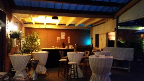 a restaurant with white chairs and a bar in the background at Plettenberger Hof in Nordkirchen