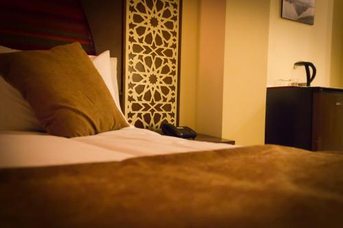 a bedroom with a bed and a phone on a table at Pyramids Valley Boutique Hotel in Cairo