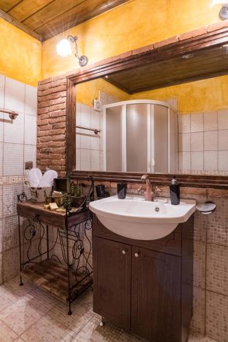 a bathroom with a sink and a mirror at Lykovrisi Guest House in Arachova
