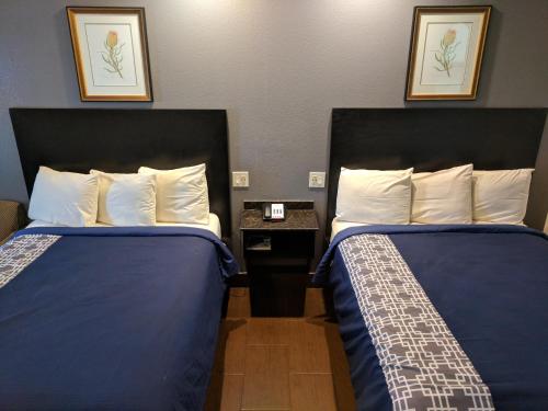 a hotel room with two beds and a table at Americas Best Value Inn - Brownsville in Brownsville