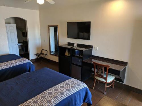 a hotel room with two beds and a flat screen tv at Americas Best Value Inn - Brownsville in Brownsville
