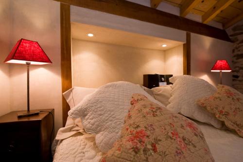 a bedroom with a bed with two lamps on it at Chez l'Autre in Chilhac