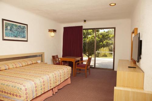 A bed or beds in a room at Hotel Paradise Inn