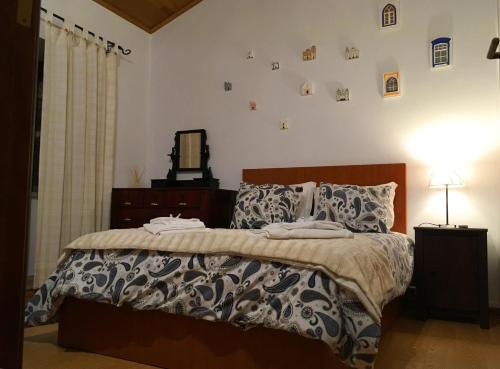 a bedroom with a bed and a mirror on the wall at Casa do Rio - Eido do Pomar in Arcos de Valdevez