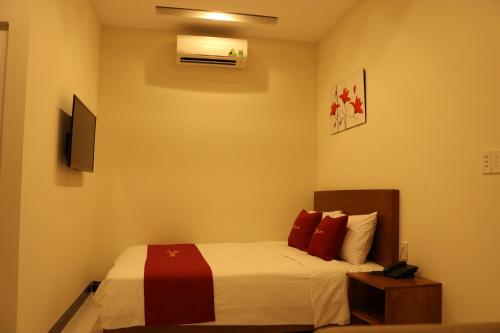 a bedroom with a bed with red pillows at Hoang Phuc Hotel in Thu Dau Mot