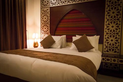 a bedroom with a large bed with a large headboard at Pyramids Valley Boutique Hotel in Cairo