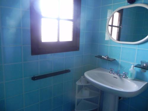 a blue bathroom with a sink and a mirror at villa rubia in Villasimius