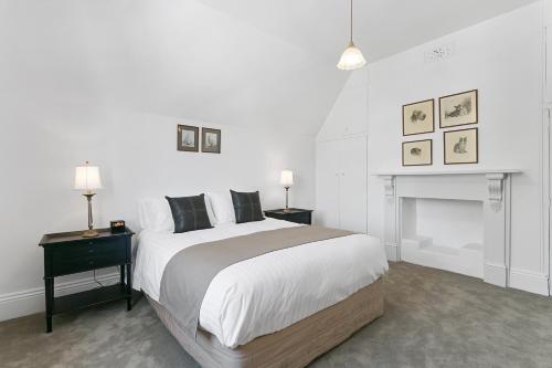 1 dormitorio blanco con 1 cama grande y chimenea en Amberley, en Sandy Bay
