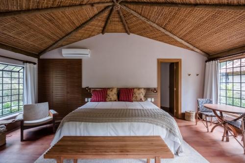 a bedroom with a bed and a table and chairs at Pousada Tankamana in Itaipava