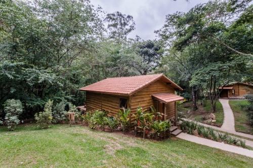 a log cabin in the woods with a yard at Pousada Tankamana in Itaipava