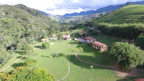 an aerial view of a house in a green field at Pousada Ribeirão do Ouro in Itamonte