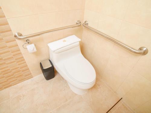 a toilet in a bathroom with a toilet paper dispenser at Golden Sunrise Machupicchu in Machu Picchu