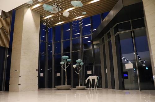 a lobby with a building with glass windows and a white sculpture at J One Hotel Cheongju in Cheongju