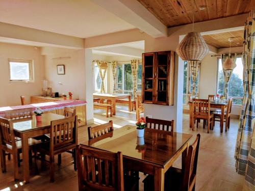 eine Küche und ein Esszimmer mit Holztischen und Stühlen in der Unterkunft Yuru Retreat Delo in Kalimpong