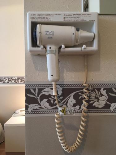 a telephone with a cord hanging from a wall at Business Hotel La Firenze in Tokyo