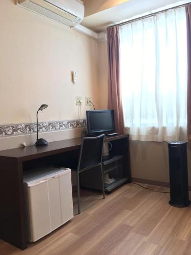 a room with a desk with a computer and a window at Business Hotel La Firenze in Tokyo