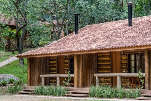 a log cabin with a tile roof at Pousada Tankamana in Itaipava