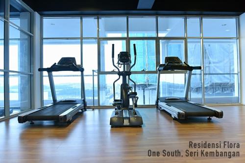 a gym with three treadmills in a room with windows at Residensi Flora in Seri Kembangan