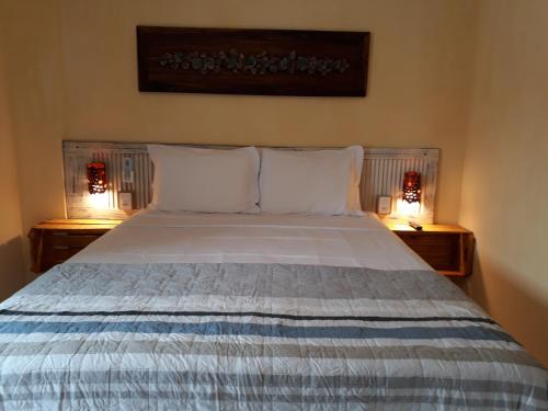 a bedroom with a bed with two lamps on either side at Vila Artesania in Bombinhas
