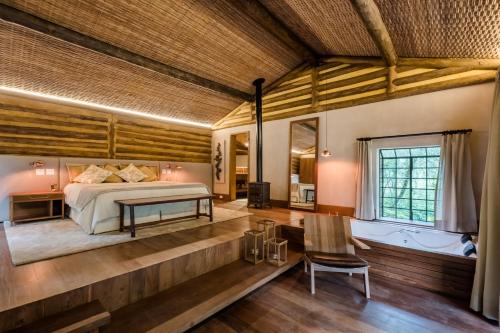 a bedroom with a bed in a room with wooden walls at Pousada Tankamana in Itaipava