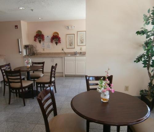 un restaurante con mesas y sillas con flores. en America's Best Value Inn & Suites-McDonough, en McDonough