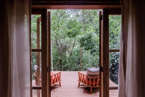 an open door to a porch with a view of trees at Pousada Tankamana in Itaipava