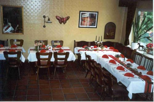 a dining room with white tables and chairs and a butterfly on the wall at Kämpgens – Hof in Mülheim an der Ruhr
