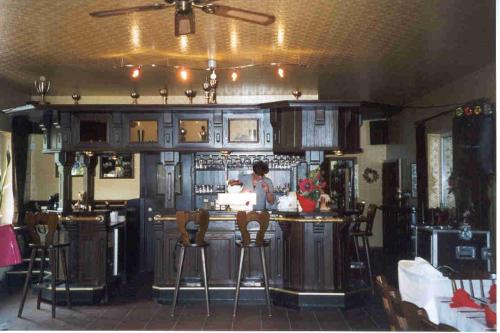 a bar in a restaurant with a person standing at a counter at Kämpgens – Hof in Mülheim an der Ruhr