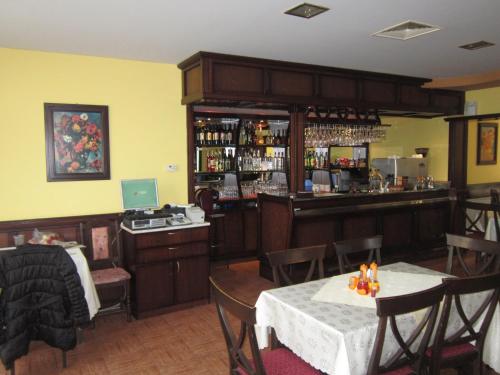ein Restaurant mit einer Bar mit Tischen und Stühlen in der Unterkunft Germanea Hotel in Saparewa Banja