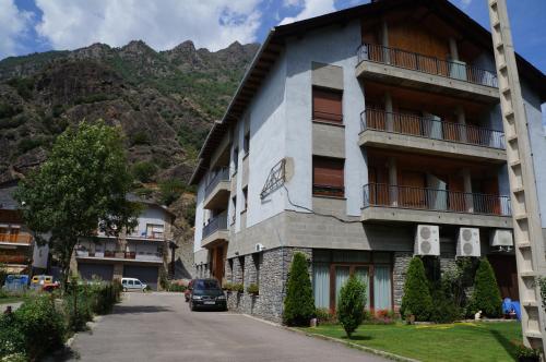 un edificio con un coche aparcado delante de él en Hotel Puitavaca, en Vall de Cardós